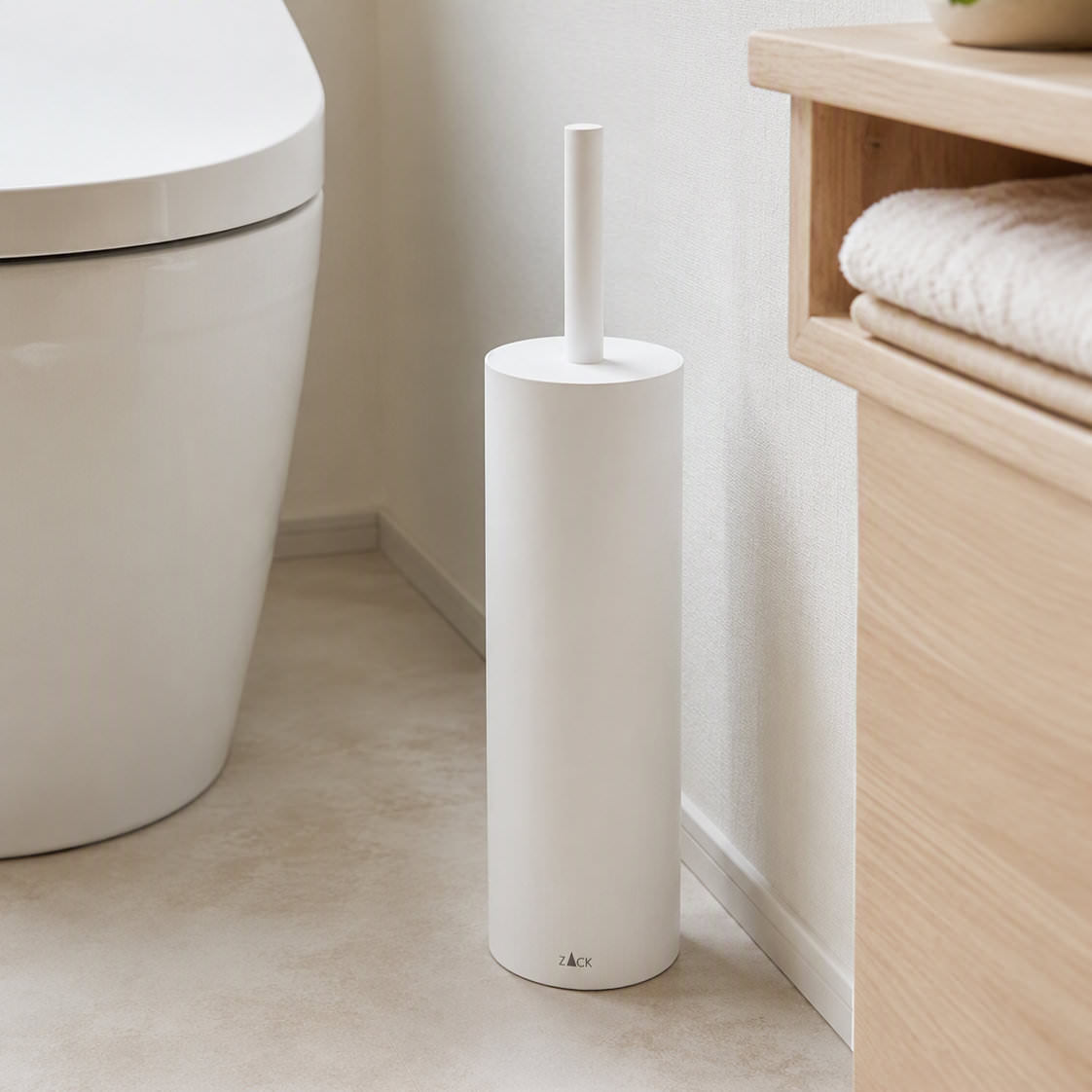 ZACK 40118 トイレブラシ:木製収納の横に白いトイレブラシを置いた設置例